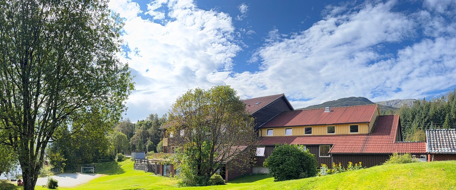 Plen mot hovedbygget under dramatisk himmel