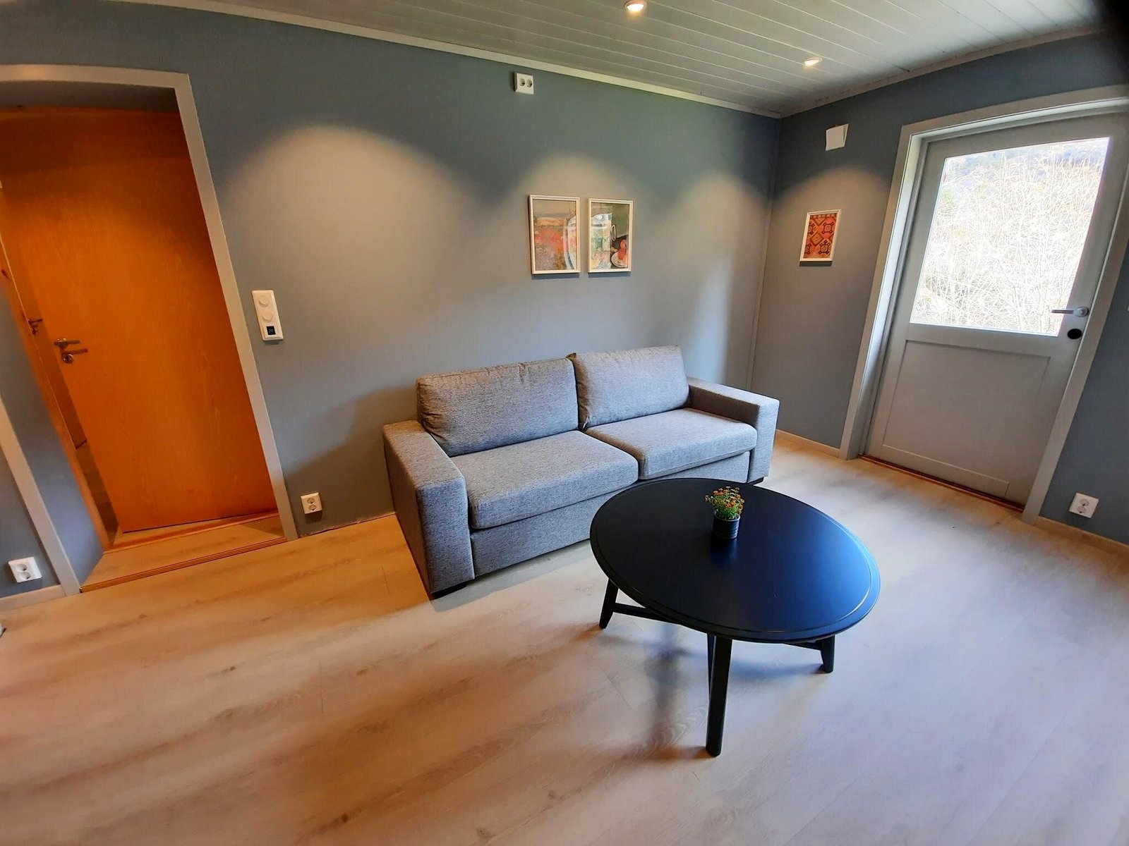 Lyst oppholdsrom med sofa og utsikt gjennom vinduet